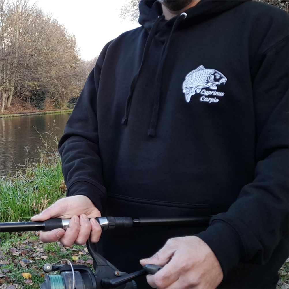 Angler wearing black carp embroidered fishing hoodie – warm carp angler hoodie for bank fishing