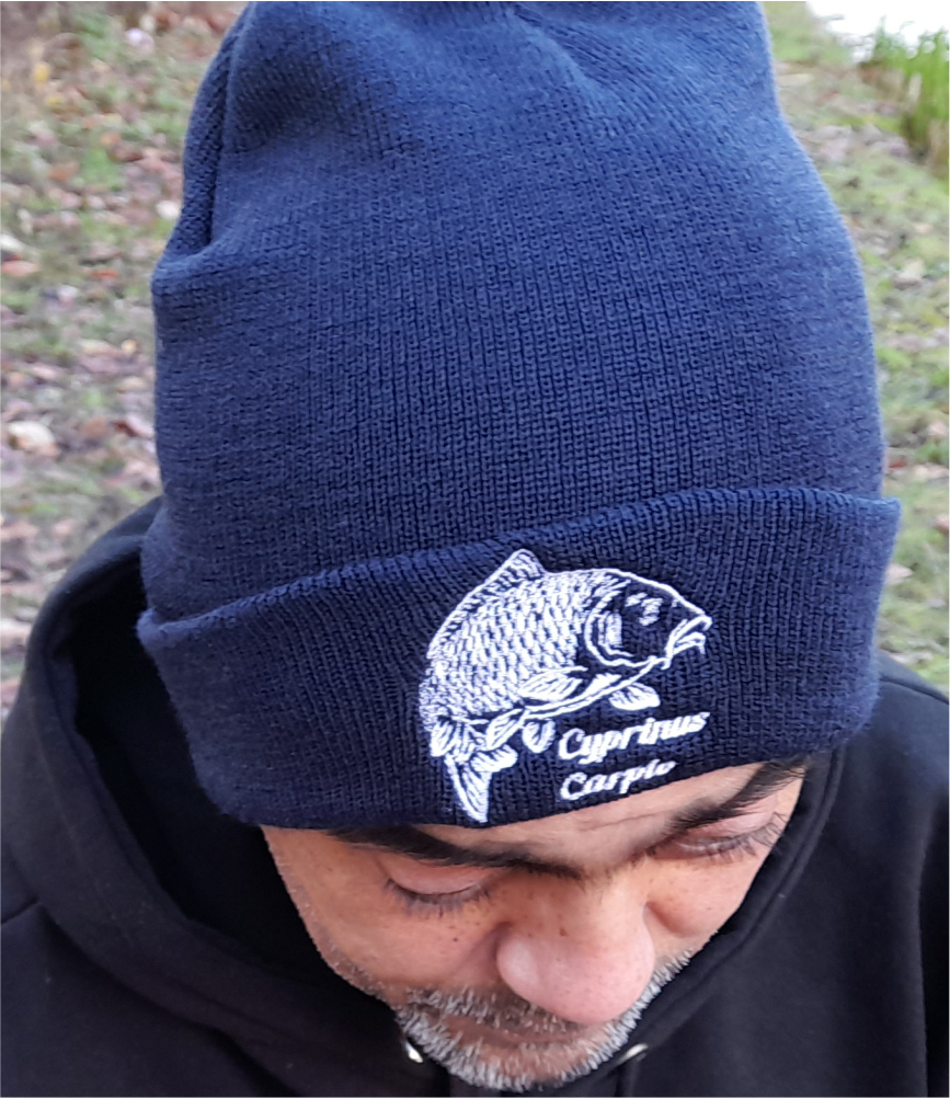 Navy fishing beanie with embroidered carp logo – worn outdoors by angler